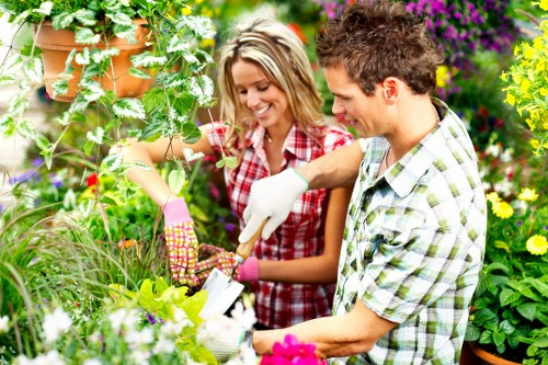 Maintenance crew pruning hedges and tending a communal garden